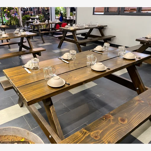 Bàn ghế gỗ thông dạng picnic phối nền gạch và tường thô