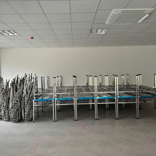 Bàn inox và ghế được sắp xếp trong phòng ăn