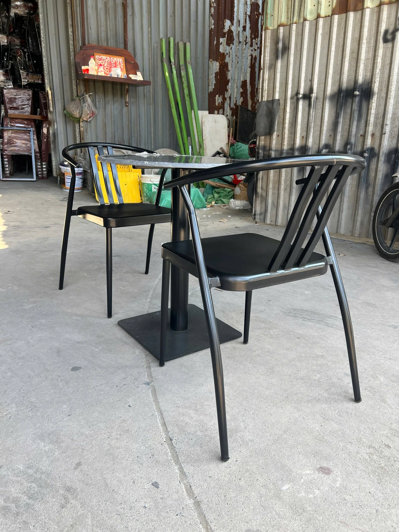 Bộ bàn ghế cafe sắt sơn tĩnh điện đen – 1 bàn 2 ghế | Xcom.vn Góc phía sau ghế cafe sắt đen với tựa cong liền tay vịn và nan đứng
