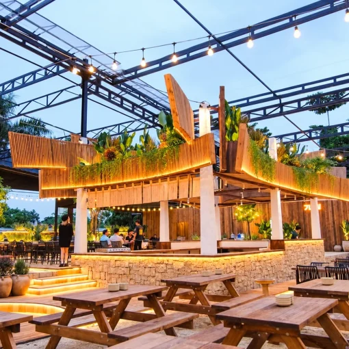 Các bộ bàn ghế picnic gỗ trong không gian quán ăn có mái che