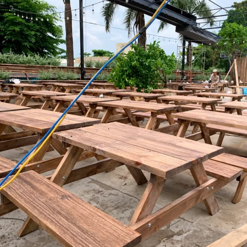 Bàn ghế băng gỗ kê theo hàng trong khu ăn uống