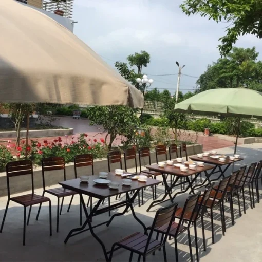 Ghế Fansipan quán ăn cao – Nhiều bàn chữ nhật và ghế quán ăn cao được sắp thành dãy ngoài trời