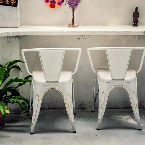 Ghế Fansipan Tolix có tay – Góc nhìn sau của các ghế Tolix có tay màu trắng và một phần ghế màu đen cạnh quầy