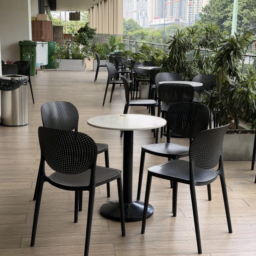 Nhóm ghế nhựa Sankyo màu đen kê quanh bàn tròn trong khu vực cafe